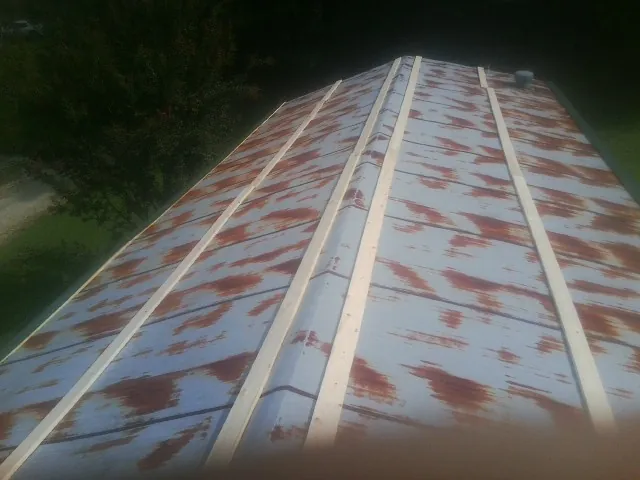 Rusted metal roof panels with new wood purlins before replacement — Storm Damage Roof Repair in Greendale by Roofing Brothers