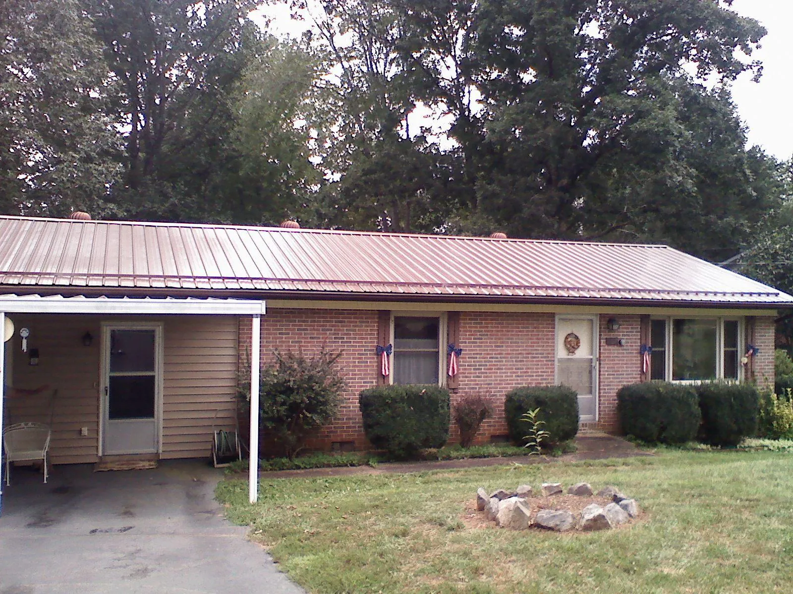 Bronze metal roof and carport on a brick ranch home — Roof Repair work by our crew in Greendale