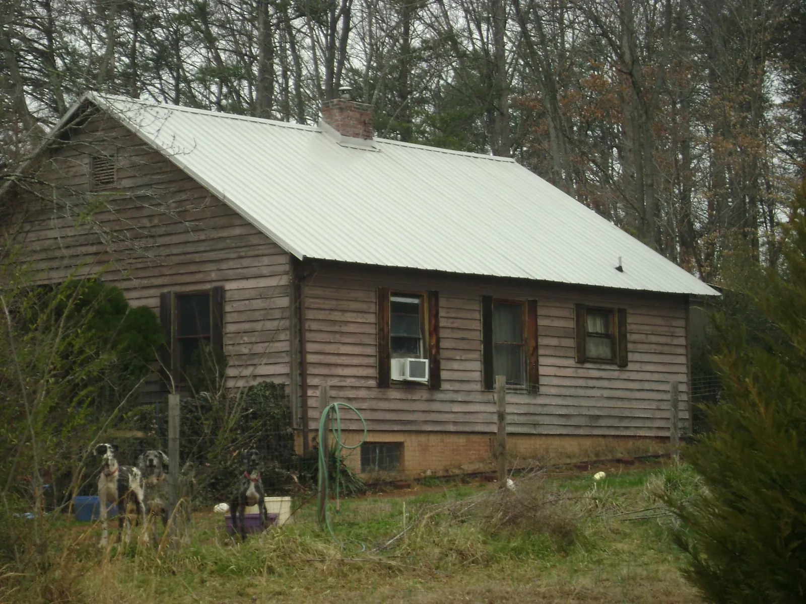 White metal roof on an old wood sided farmhouse, from a Metal Roof Installation job in Greendale